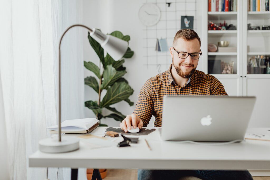 A young man working from home on his computer.