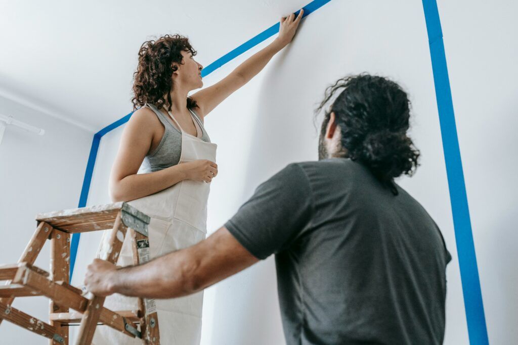 A couple working on a painting project for improving their home.